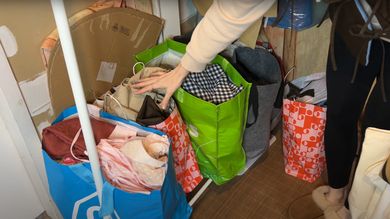 bags of clothes and fabric in attic room