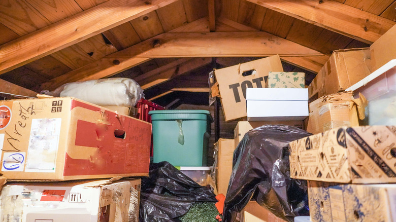 pile of boxes and plastic bins under exposed joist ceiling