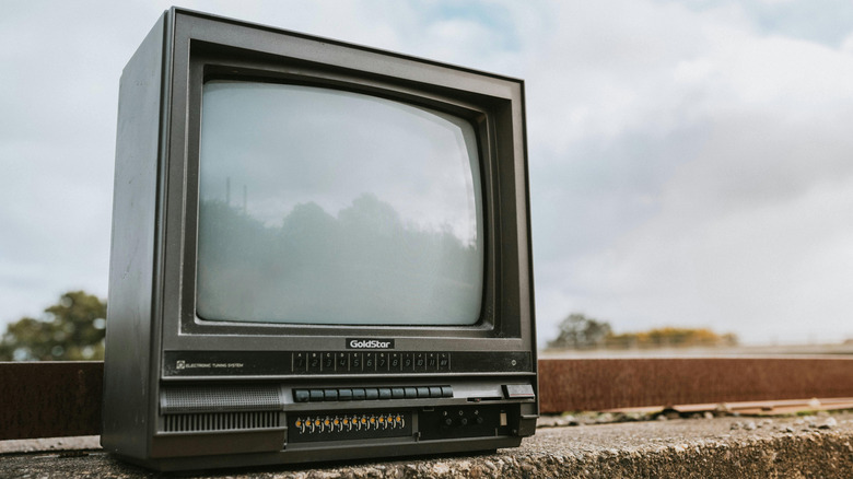 old tube TV on rock outside