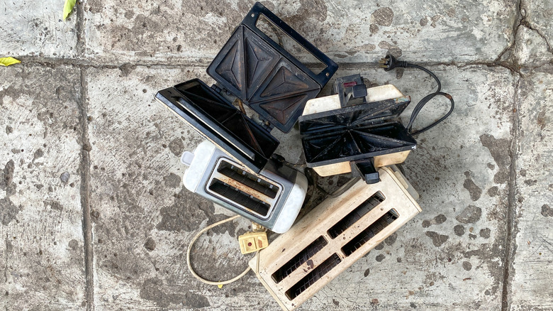 old and broken vintage kitchen appliances on sidewalk