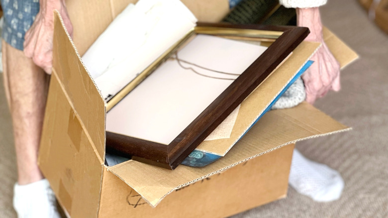 woman holding a box of empty picture frames