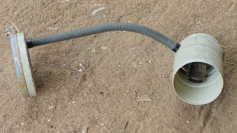 broken and dirty desk lamp on ground