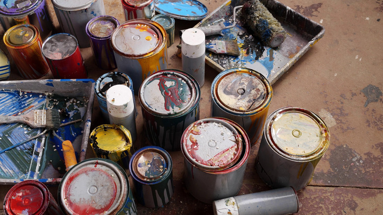 various rusty paint cans and dirty tools