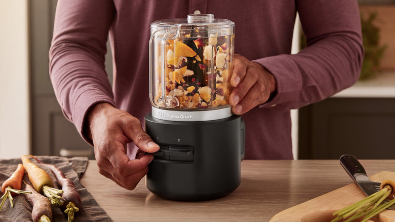 Man uses KitchenAid cordless appliance in kitchen.