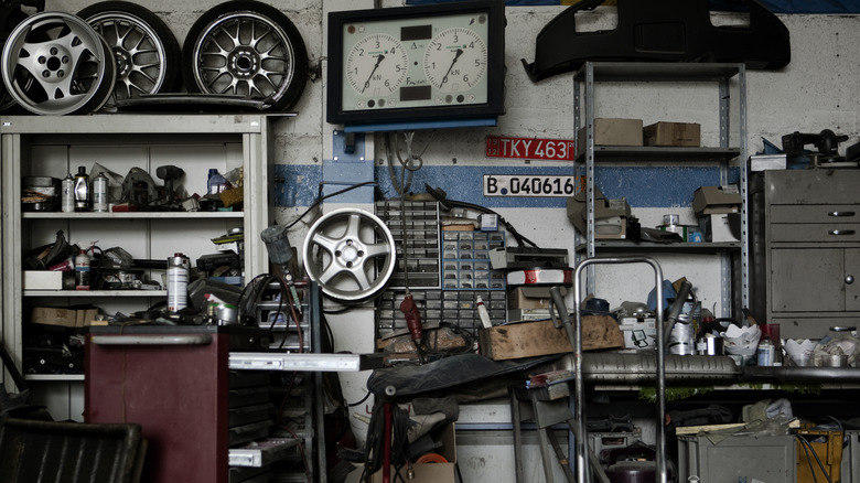 Car tires, broken parts, and other items in messy garage