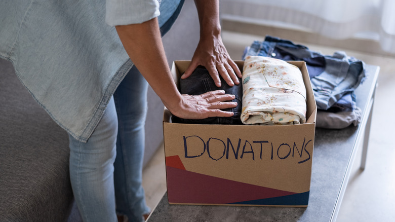 Person putting items for donation in a box