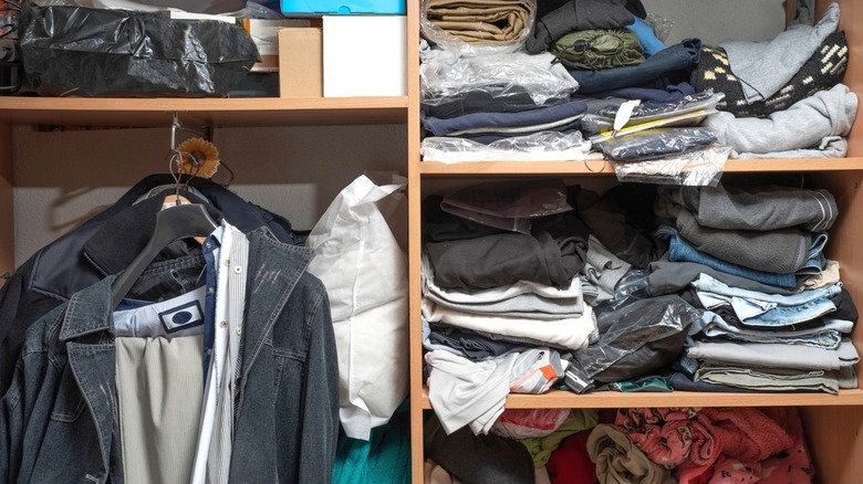 cluttered closet shelves filled with clothes