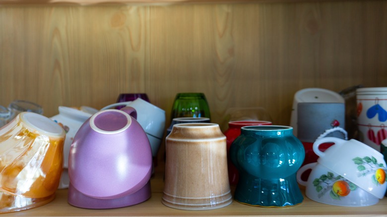 Cluttered coffee mugs in cabinet