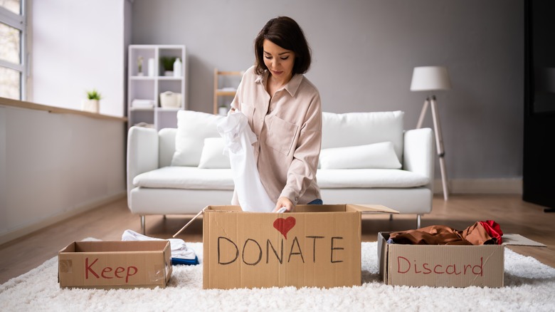 woman placing clothes in boxes