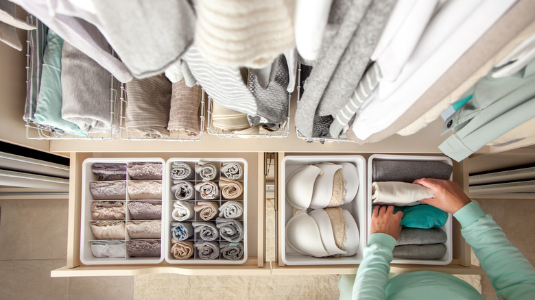 person placing clothes in drawer