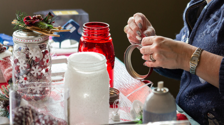 A woman creates Christmas decorations with mason jars