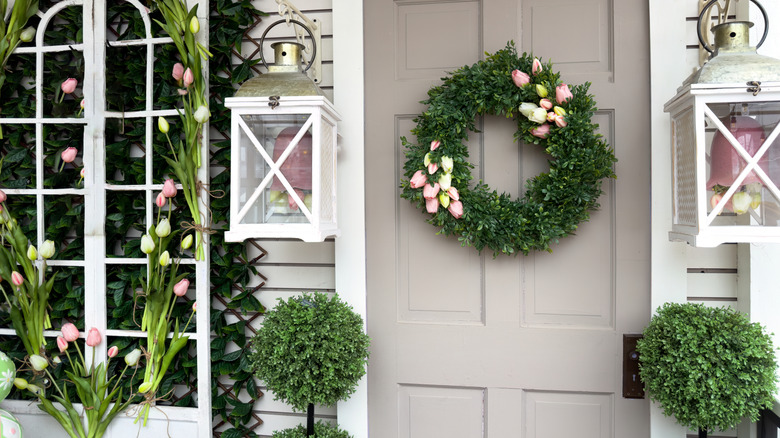 A porch decked out for spring, including a tulip arch and wreath