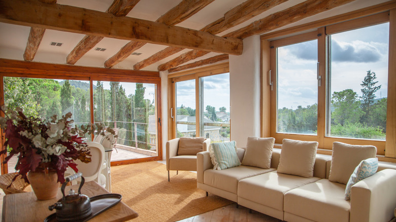 Living room with wood trimmed windows, doors, and exposed beams in the ceiling