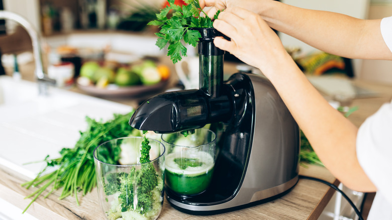 Making green juice in juicer