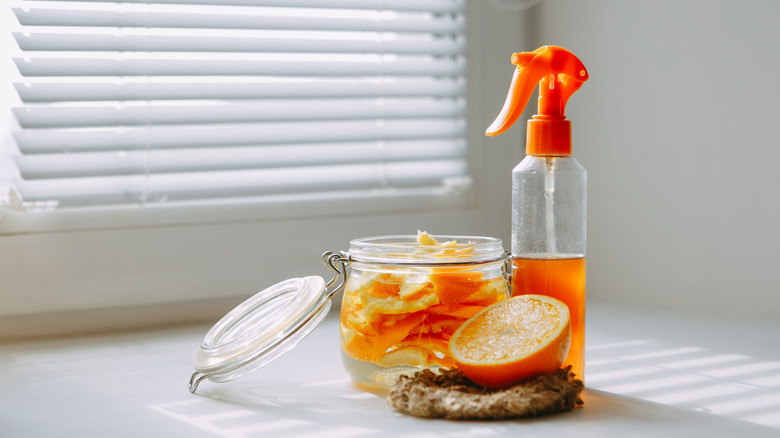 a bottle of cleaning solution made from oranges sitting in front of a window