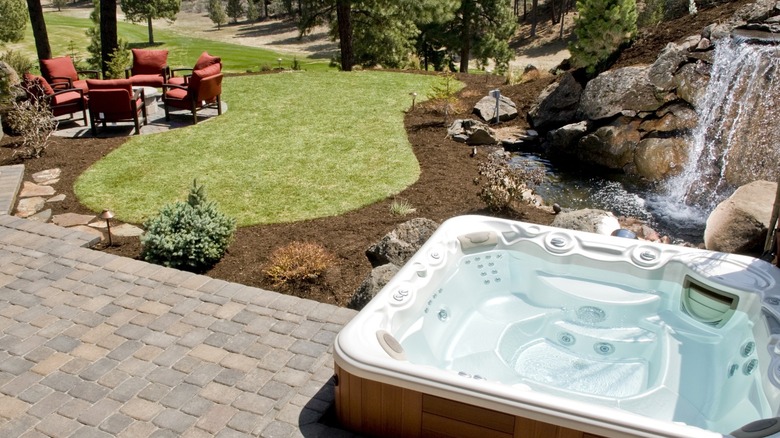 Backyard patio with hot tub and waterfall feature