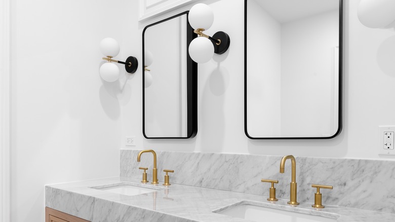 Bathroom with wall sconces over sink