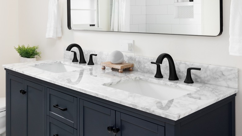 Navy blue vanity with white marble top and black hardware