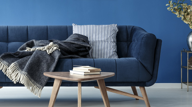 blue sofa with pillow and throw