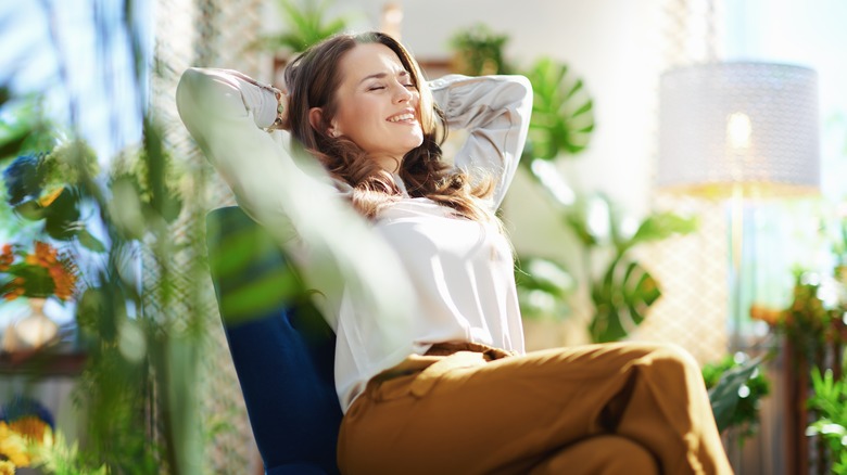 woman sitting among houseplants