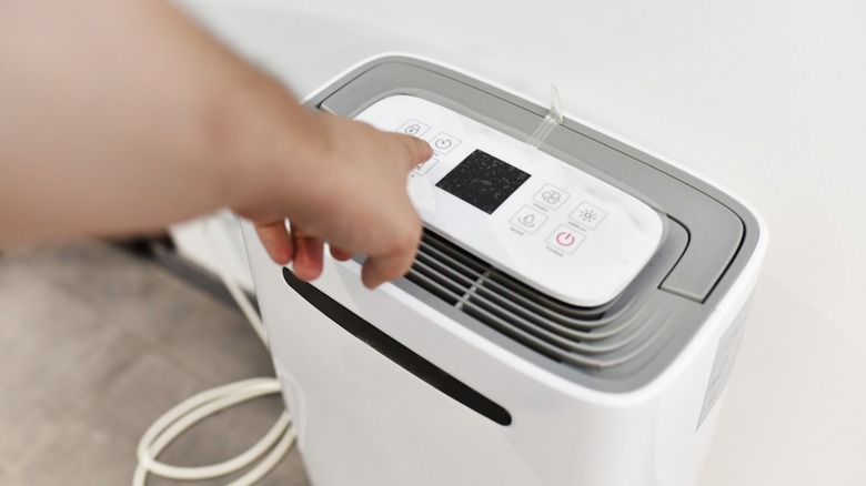 person switching on dehumidifier