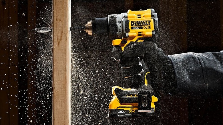 DeWalt cordless drill drilling a hole in a wall stud