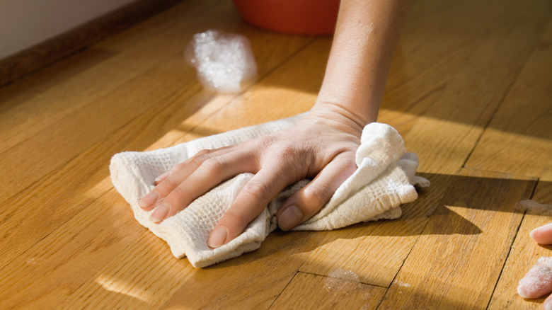 Hand scrubbing hardwood floors with cloth