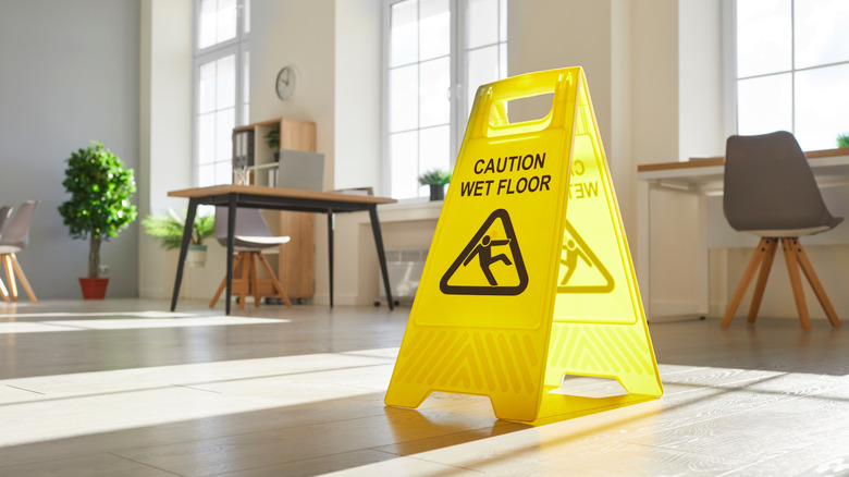 Yellow wet floor sign in office space