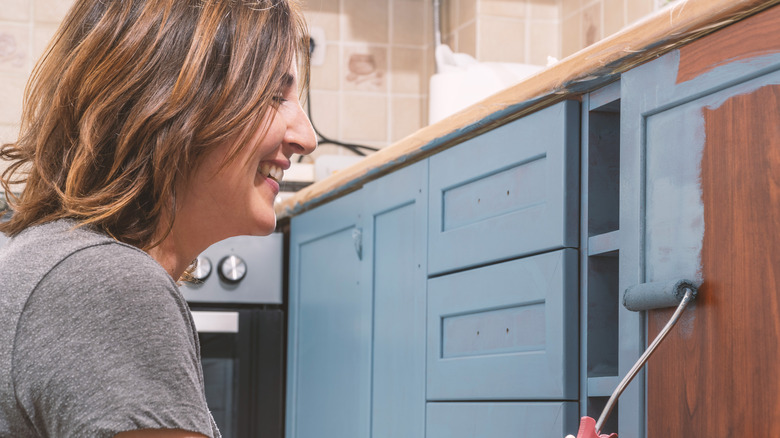 woman painting cabinets