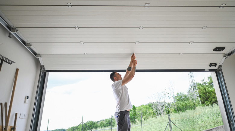 Man working on an open sectional garage door