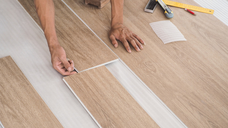 A person installing loose lay flooring