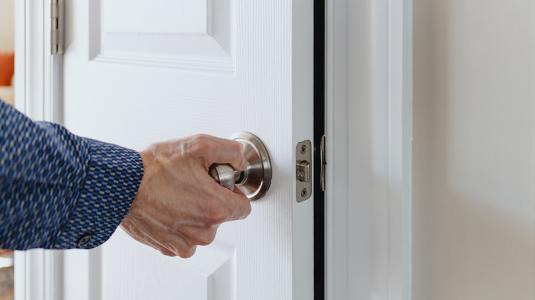 A man opens a basic closet door