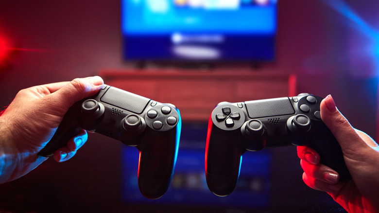 hands holding video game controllers
