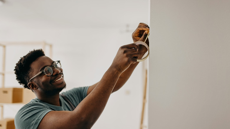 man applying painters tape