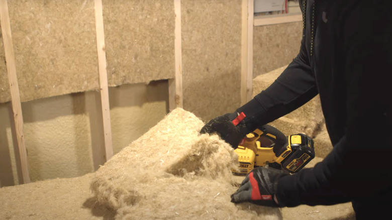 insulation installer tearing hemp wool