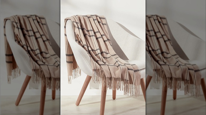 Beige plaid blanket tossed on a chair