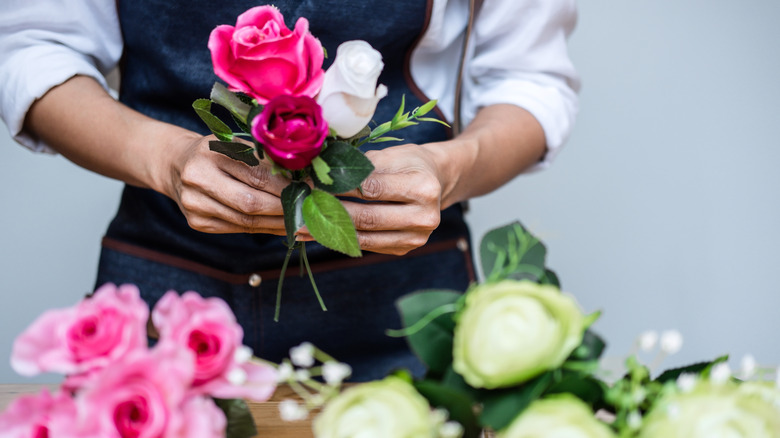 person arranging faux flowers