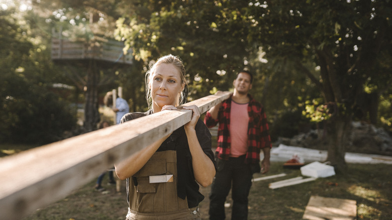 woman carrying lumber