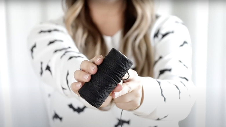 Woman holding black twine