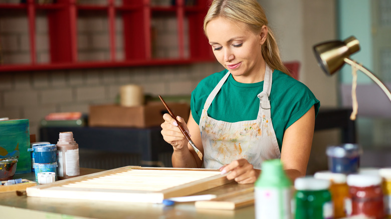 Woman painting picture frame