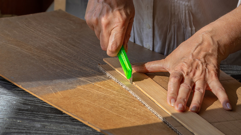 A woman cuts cardboard with a box knif