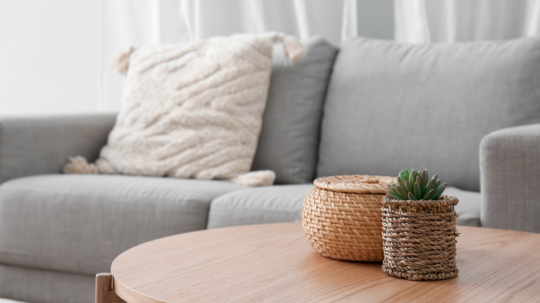 Wooden end table to the side of the living room couch