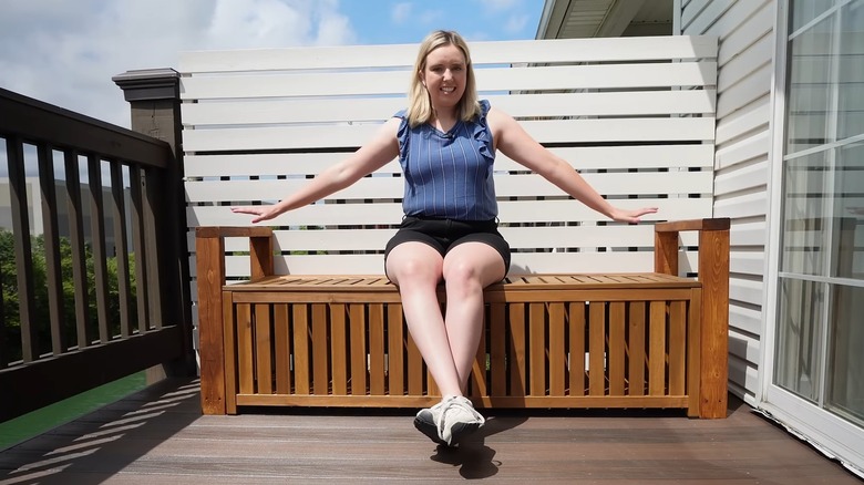 woman sitting on wooden outdoor bench