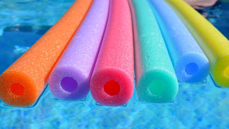 Colorful pool noodles floating in the pool