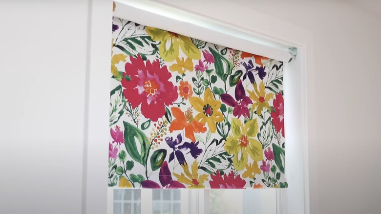 A blackout roller shade with colorful floral fabric attached on top