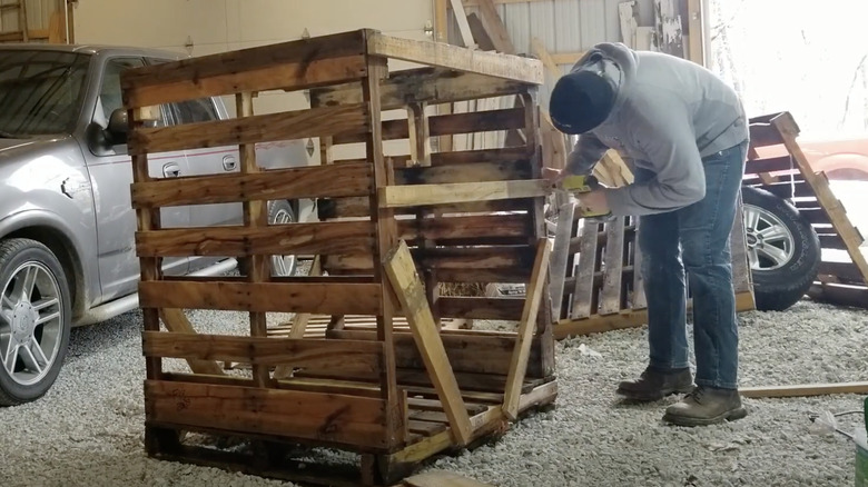 person building pallet firewood rack