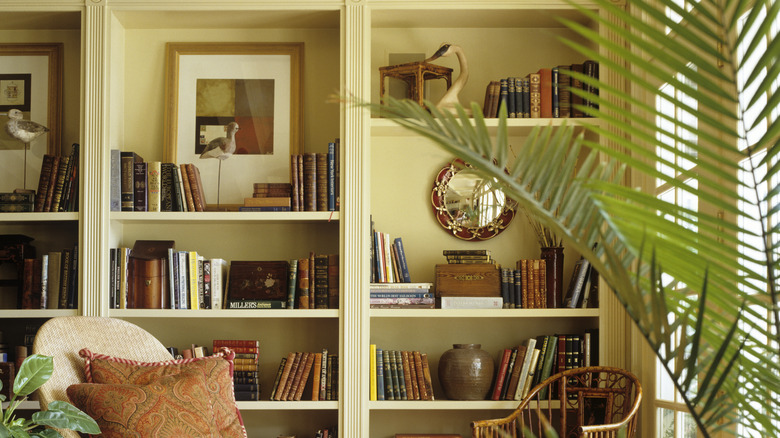 A back wall of a room is converted into built-in bookshelves full of books and decor