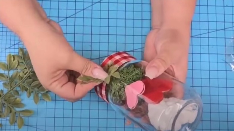 Woman holding DIY Valentine's Day terrarium