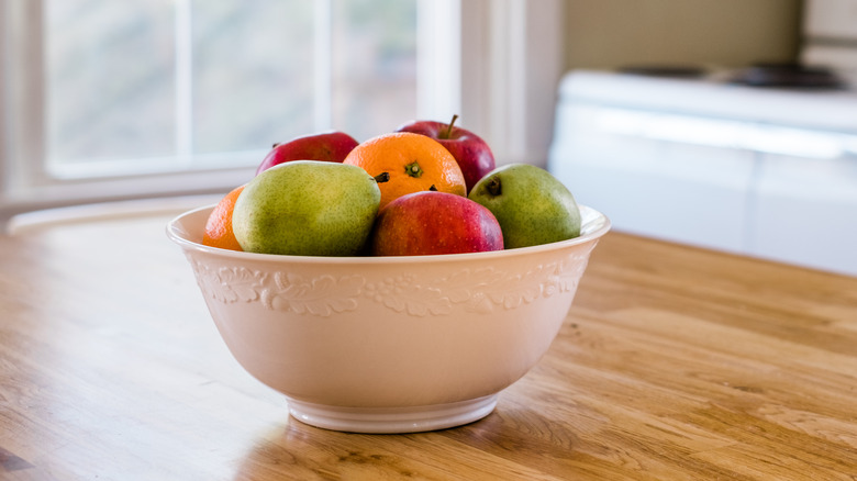 Fruit in a white bowl on a wood table