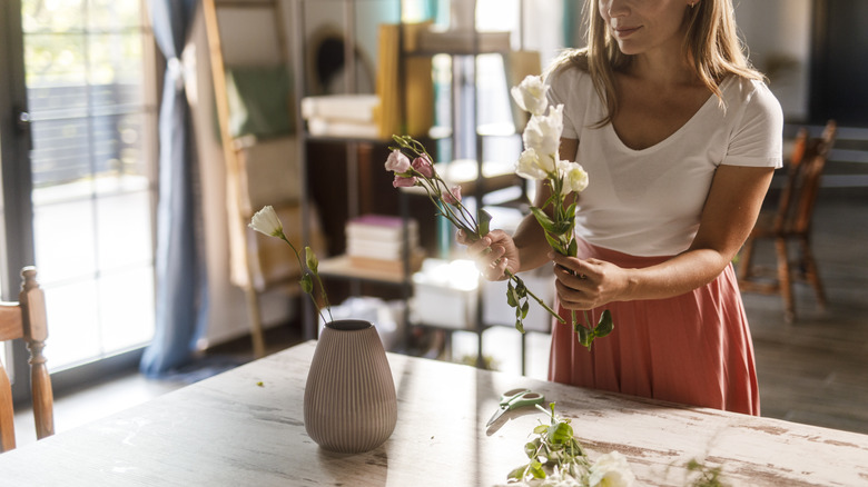 Person creating floral centerpiece